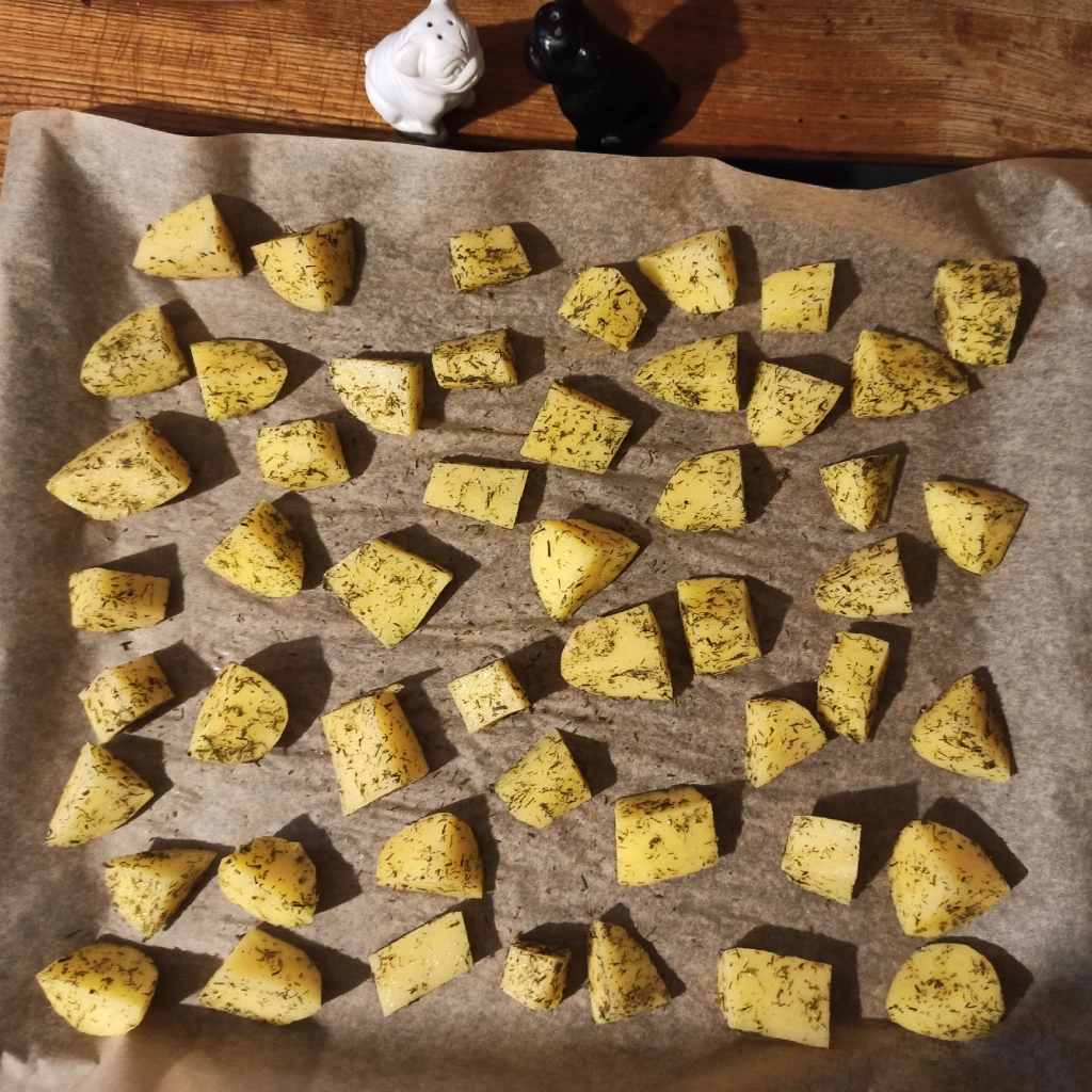 surowe ziemniaki rozłożone na blasze do pieczenia